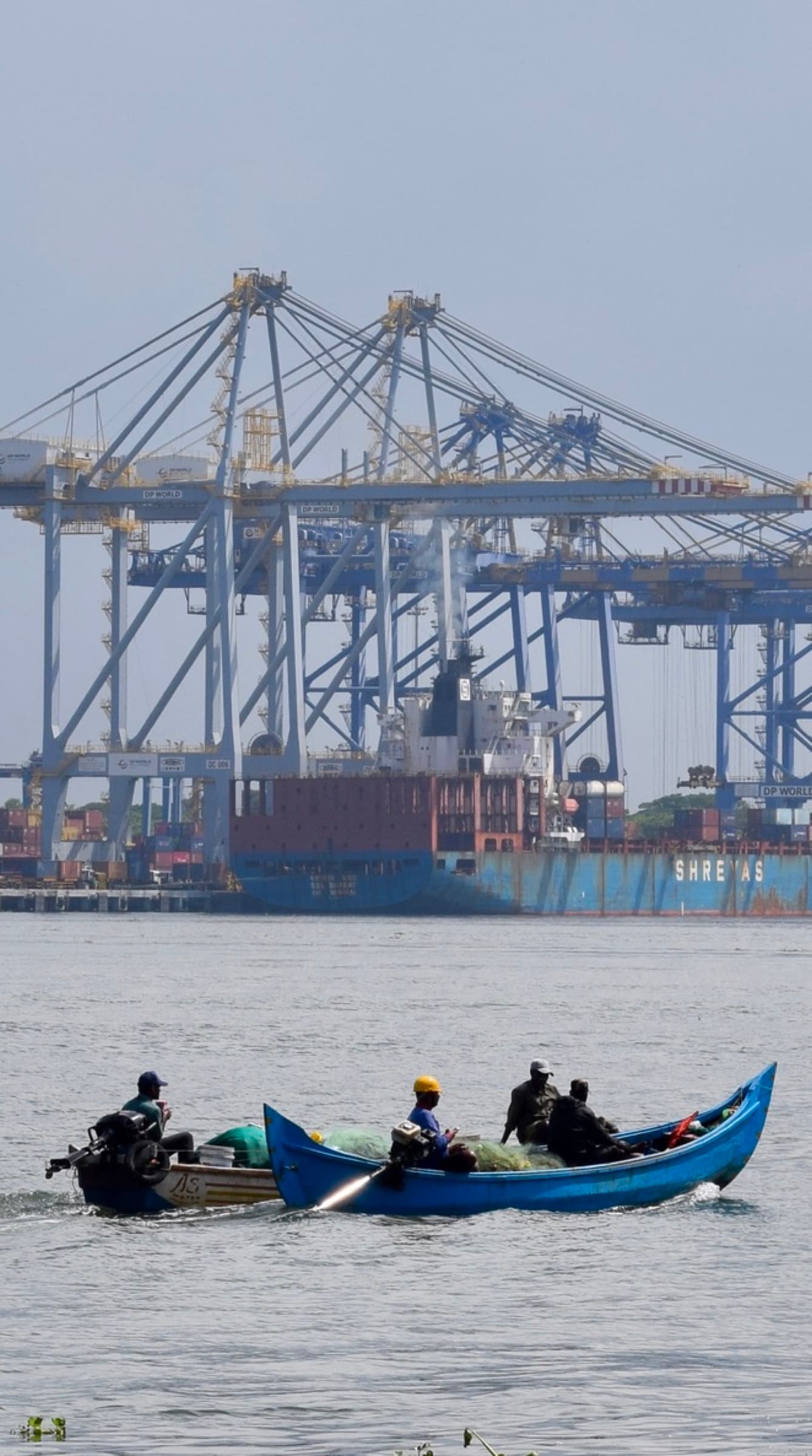 Fishermen crossing Kochi harbour in a blue boat